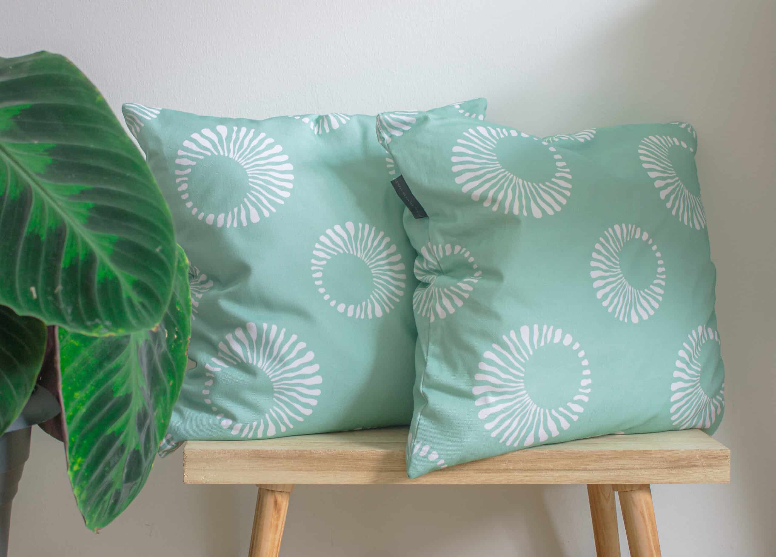 two mint green cushions on a bench