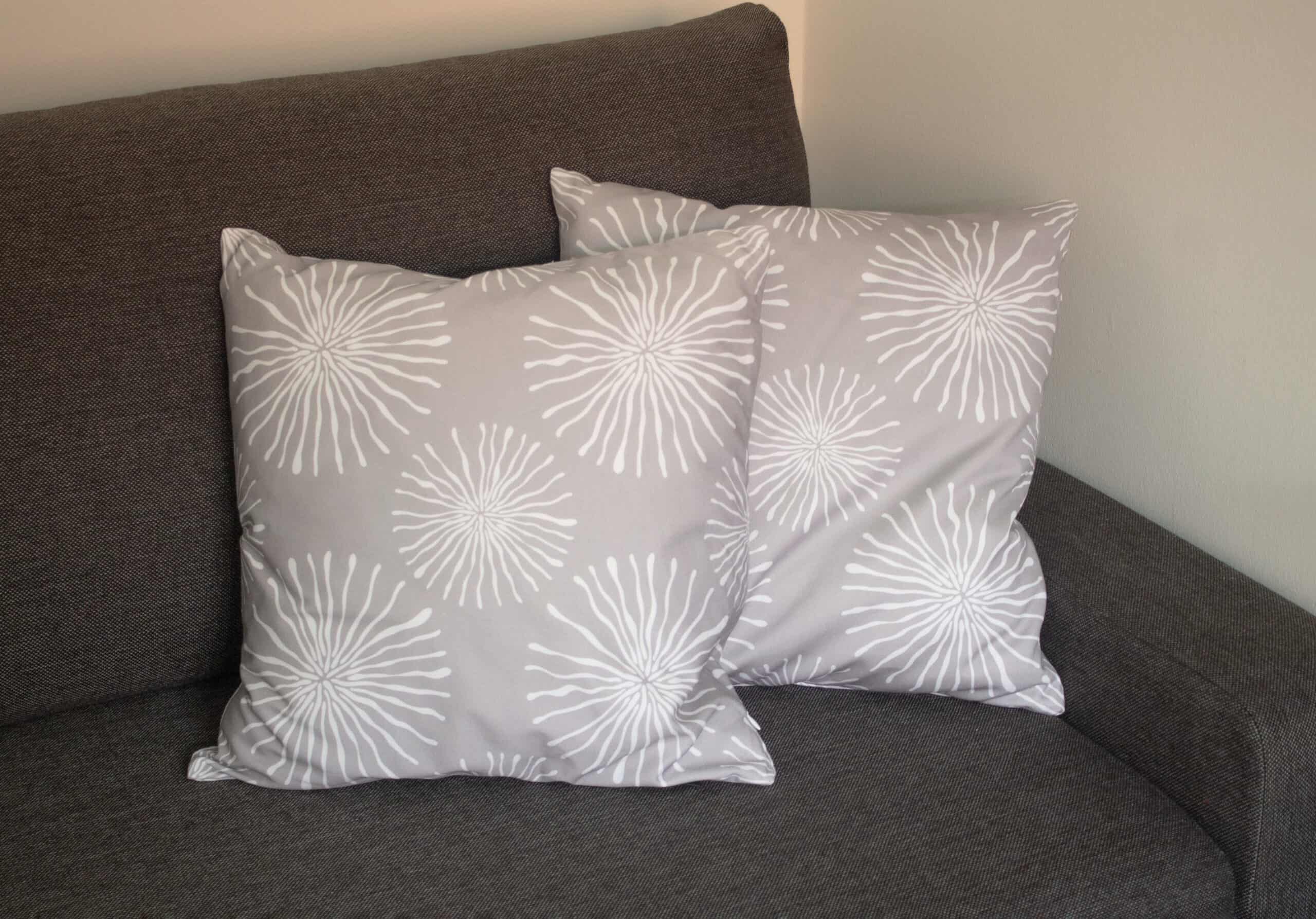 two light grey cushions with white circle pattern on dark grey couch