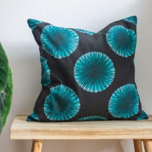 Turquoise Throw Cushion in black and turquoise blue pattern on bench