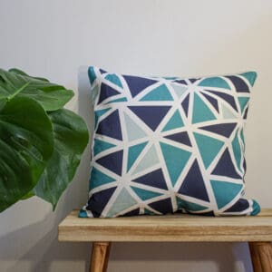 Geometric Throw Cushion Blue and Midnight blue Triangle Pattern Design on a bench with a plant